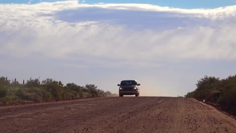 una camioneta conduce por un camino de tierra