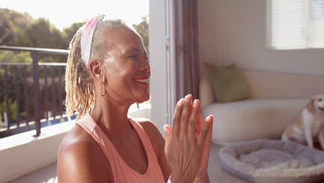 a senior african american woman with grey dreadlocks is laughing