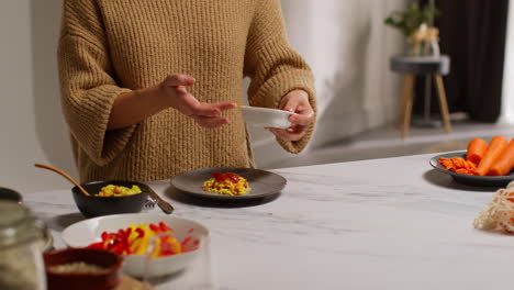 close up of woman at home in kitchen preparing healthy vegetarian or vegan meal of orzo pasta and roasted tomatoes 1