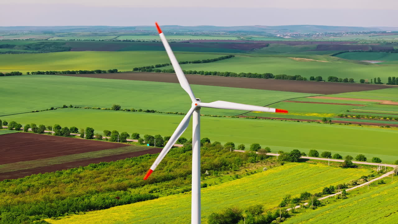 Aerial drone view of a wind turbine in a field on a cloudy day