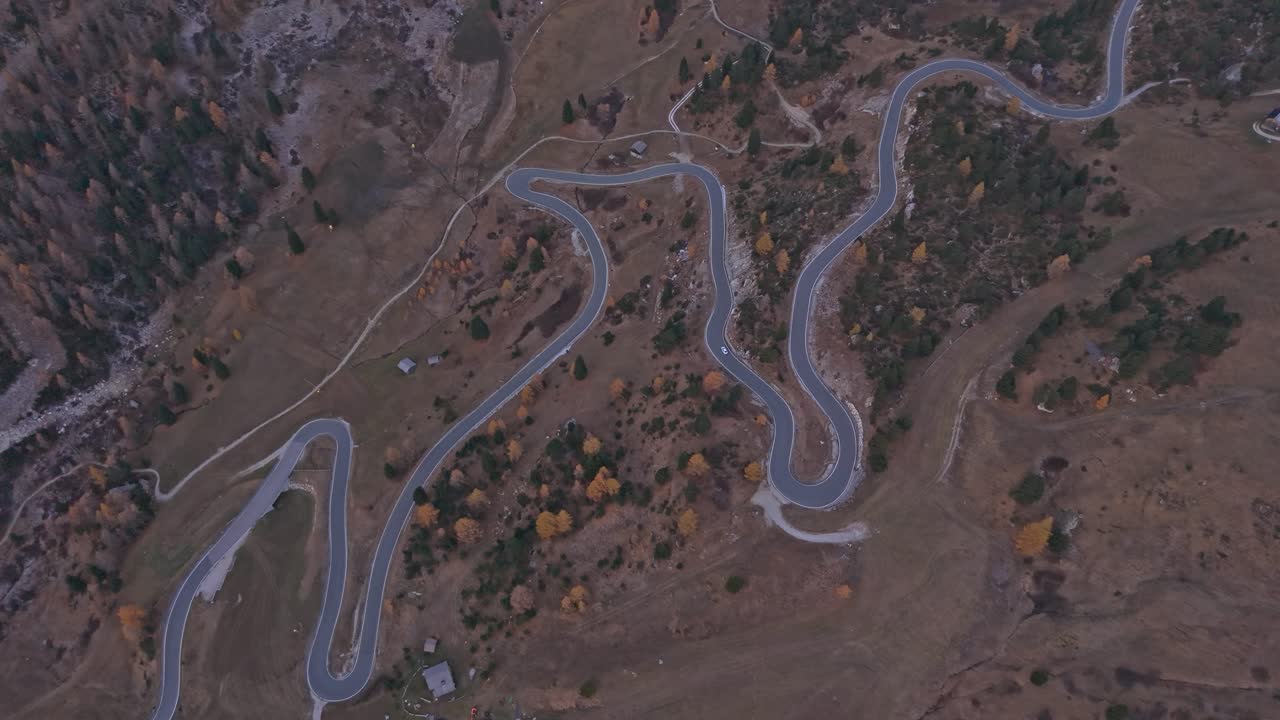 High-angle view of car on Gardena mountain road at sunrise in Italy