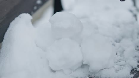 Slowmotion-Nahaufnahme-Der-Vorbereitung-Eines-Schneeballhaufens-Mit-Schwarzen-Handschuhen