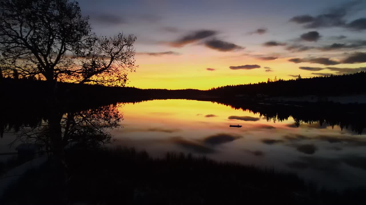 Glimpse Lake at colorful dramatic sunset from dock, aerial drone shot