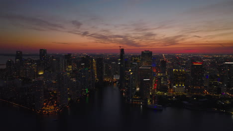 Modern-high-rise-downtown-skyscraper-on-waterfront-against-romantic-colourful-twilight-sky.-Aerial-panoramic-evening-shot.-Miami,-USA