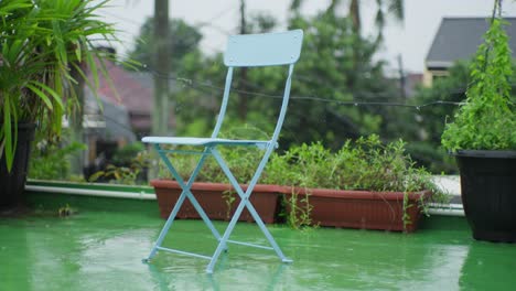 Silla-De-Acero-Pintada-De-Azul-En-Un-Jardín-Lluvioso