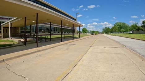 sunny day views of a road by a school and baseball field