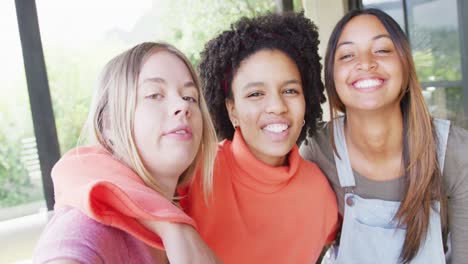 portrait of happy diverse teenager girls friends embracing at home, slow motion