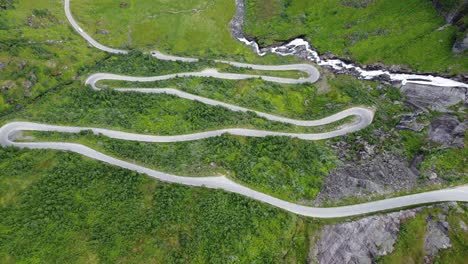 halsabakkane winding roads leading to vikafjellet mountain crossing in western norway - unique curvy road climbing up steep mountain hill in lush green valley - descending birdseye aerial