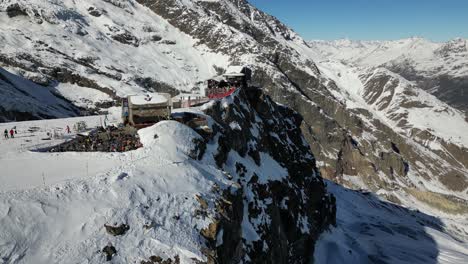 Toma-Panorámica-Aérea:-Fachada-Rocosa-De-Una-Montaña-Nevada-En-Los-Alpes-Suizos