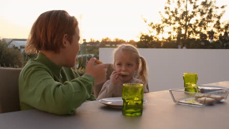 Siblings-eating-small-pizzas-during-dinner