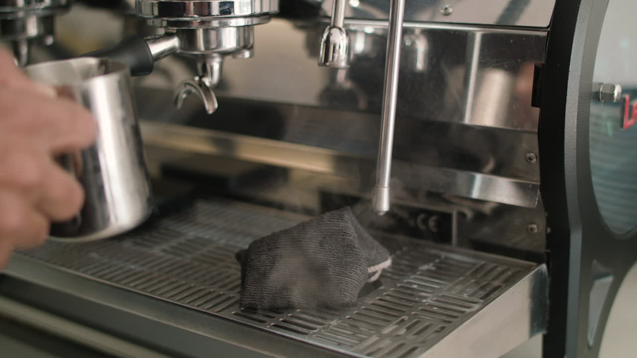Slow mo close up of a puff of steam coming out of a cafe milk steamer