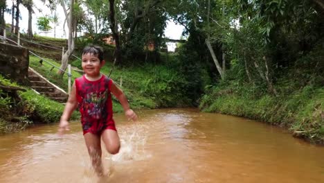 child running towards camera in slow motion in unpolluted water stream
