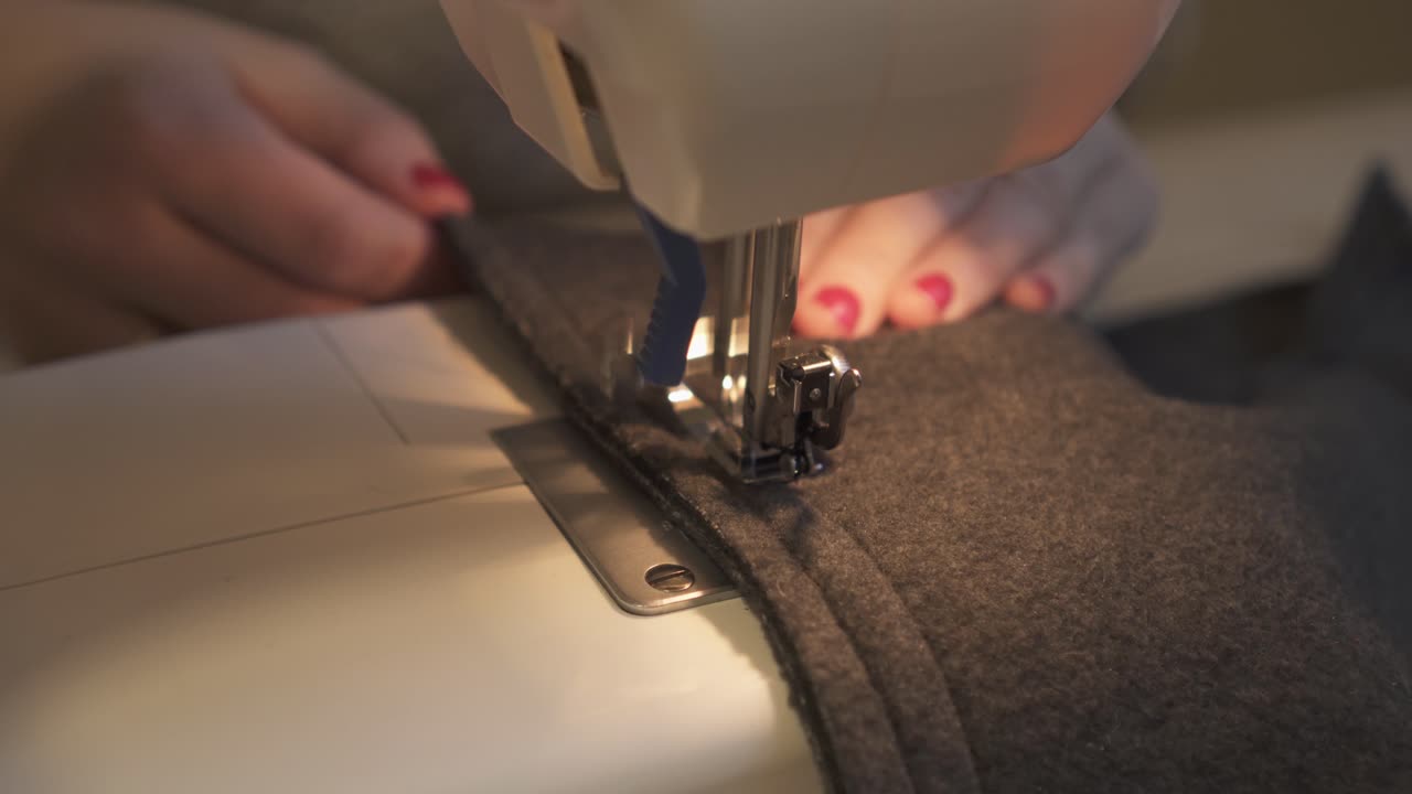 mujer sastre trabajando en la máquina de coser - cerrar