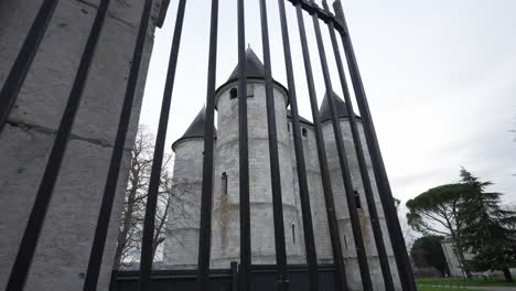 castle fortress in view behind metal fenced bars on cloudy overcast day