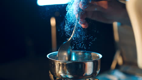 young man preparing a drug. man holds a spoon over a cigarette lighter. drugs and the concept of crime.