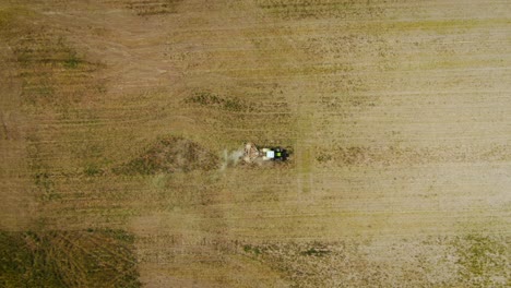 top down view of tractor mowing weeds on agricultural field in almaty, kazakhstan - aerial drone shot