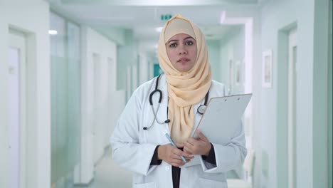 serious muslim doctor talking to patient