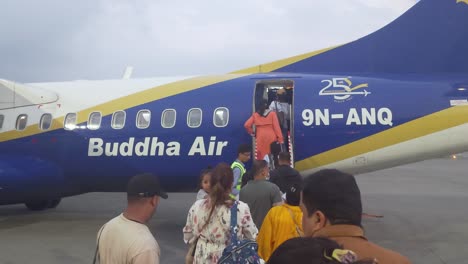 passengers boarding buddha air plane at airport