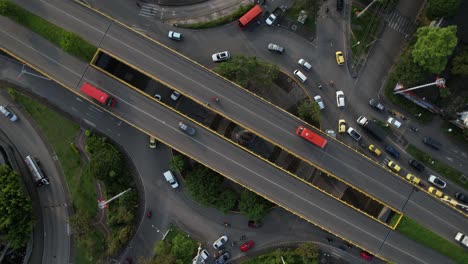 Drone shot of roundabout and urban traffic in a Colombian city. 360-degree panoramic view showing roads, vehicles, and surrounding buildings.