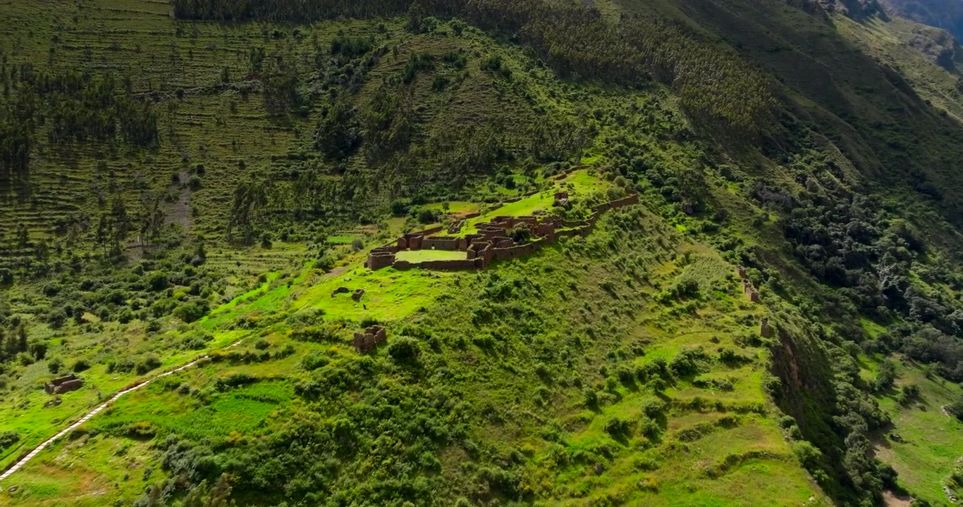 Antiche terrazze agricole Inca e rovine su un verde pendio nella storica città di Ollantaytambo, Valle Sacra, Perù. Drone aereo.