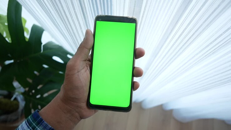 Hand holding a green screen phone