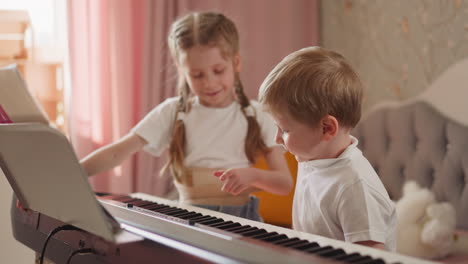 positive girl shows music sheets and piano keyboard