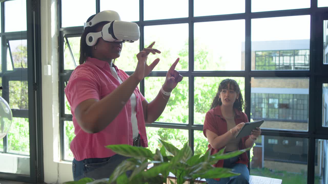 Donne afroamericane che testano la VR vicino alla finestra, con l'utente del visore che fa gesti più ampi dopo un tocco sul tablet.