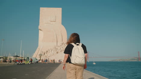 tourist walking near the monument to the discoveries in lisbon, portugal