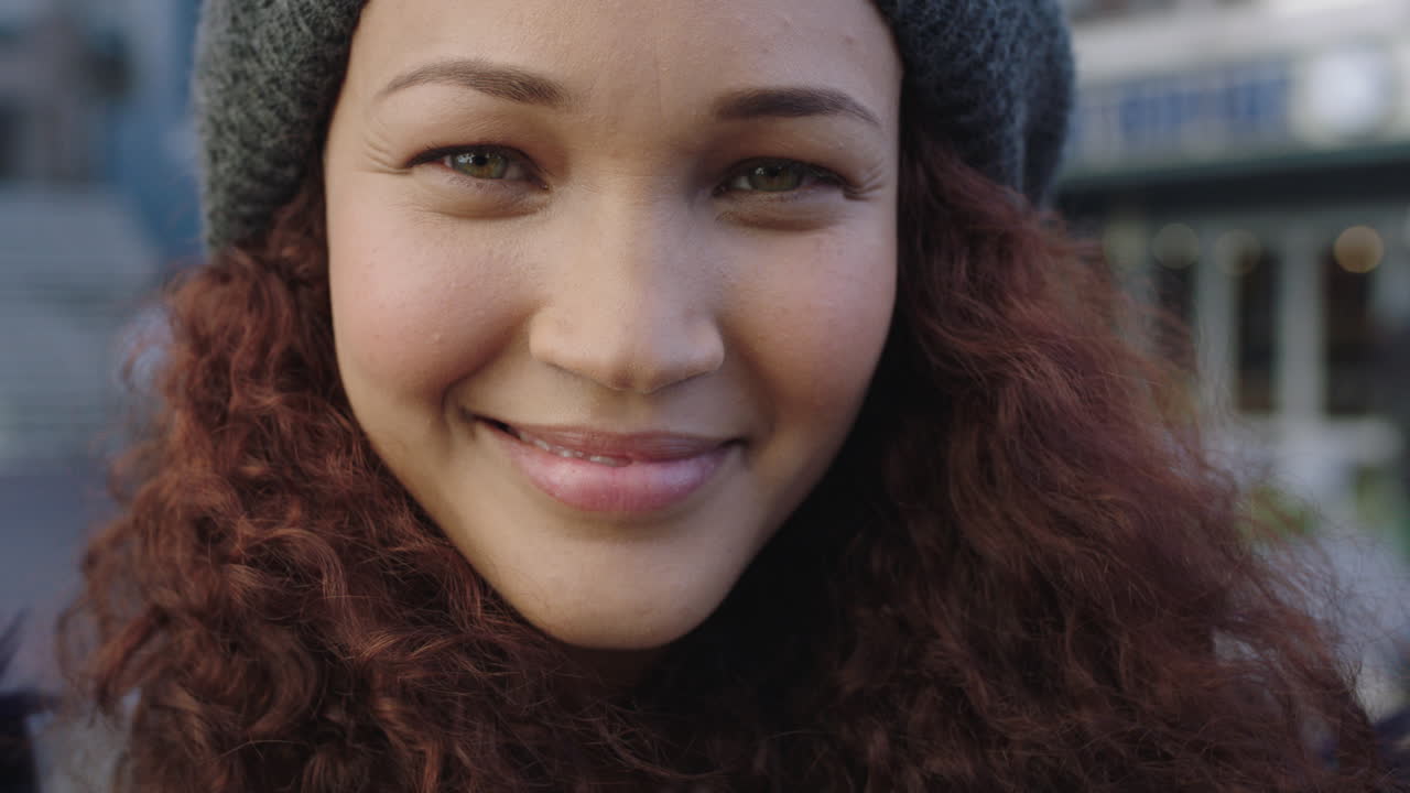 retrato en primer plano de una hermosa mujer de raza mixta con el cabello rizado sonriendo feliz mirando a la cámara