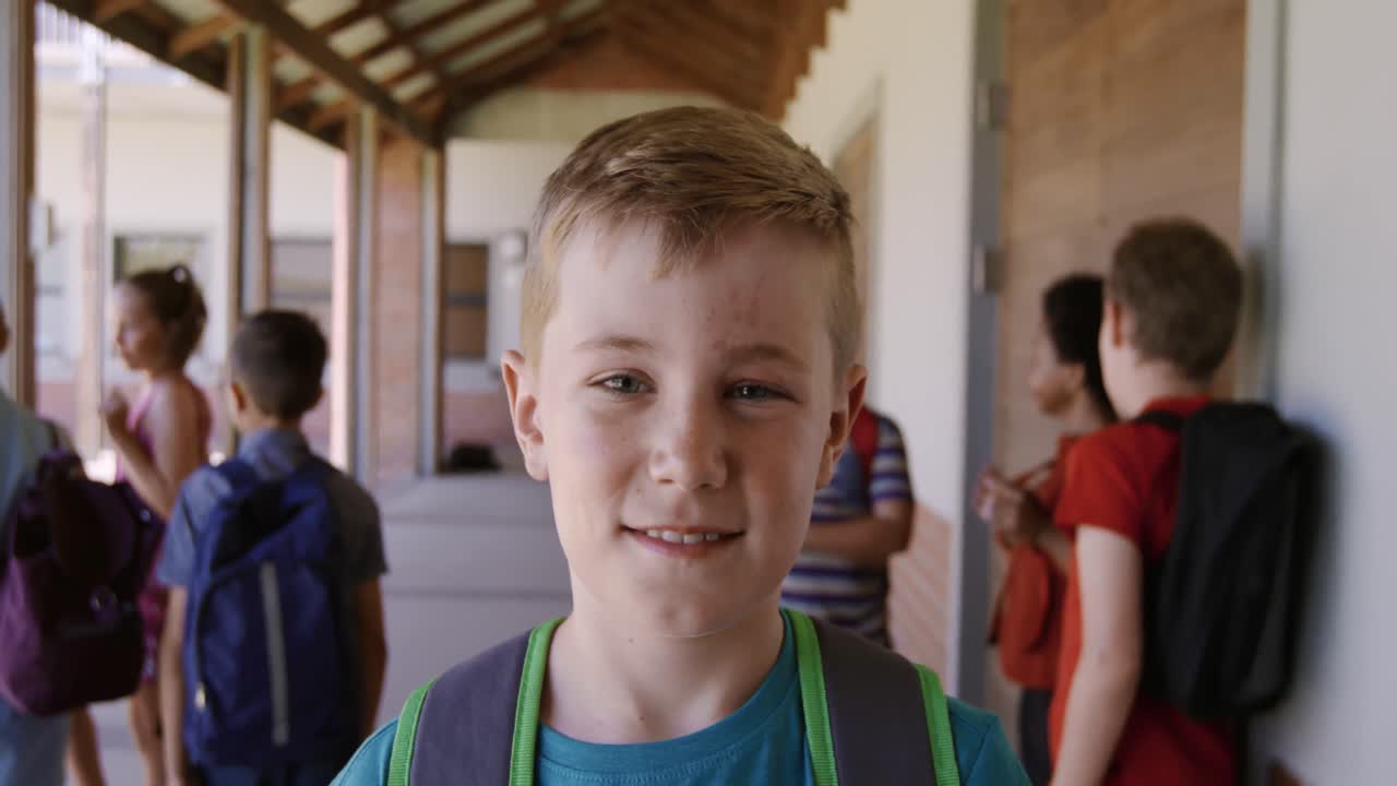niño sonriendo en el pasillo de la escuela