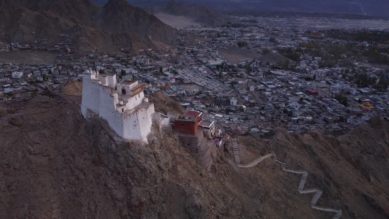 toma cinematográfica del monasterio y el templo de sankar con vistas a la ciudad de leh en el fondo durante la puesta de sol, ladakh, india