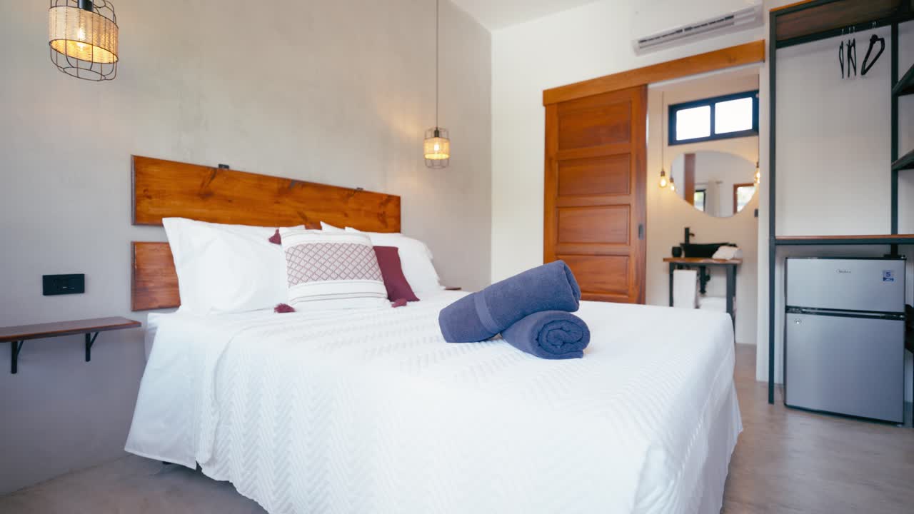 Modern Hotel Bedroom Interior with Clean White Bed and Bathroom Access