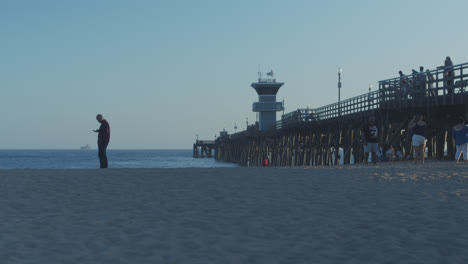 seal beach pier with a guy on his cellphone