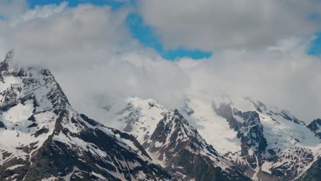 vuelo aéreo a través de nubes montañosas sobre hermosos picos nevados de montañas y glaciares.