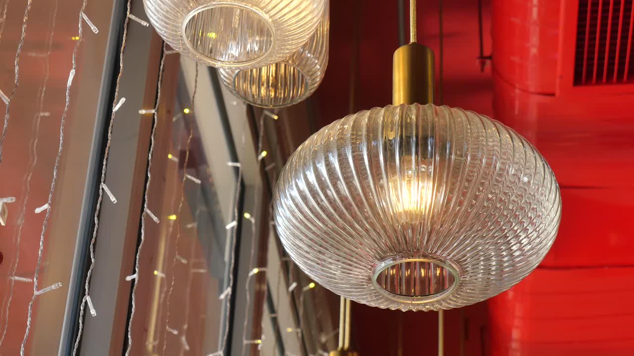 Nærbilde av belyste pendellamper i riflet glass