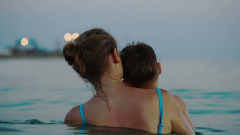 Madre-E-Hijo-En-El-Mar-Mirando-El-Muelle-Con-Barcos