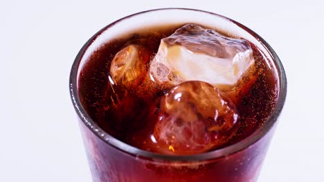 coca cola is poured into a glass from a bottle