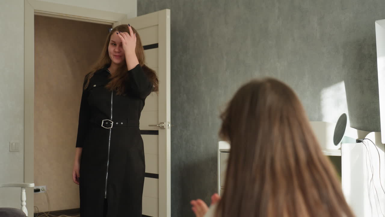 School girls in modern bedroom, one seated on bed while best friend walks in joyfully from open door, spins happily, long hair flowing, smiling as roommate watches with delight, warm daylight