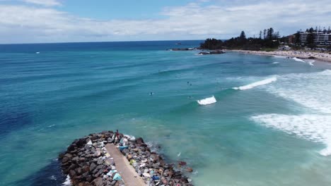 Aerial-view-of-a-beautiful-Australian-beach-showing-a-pier-and-a-coastal-town