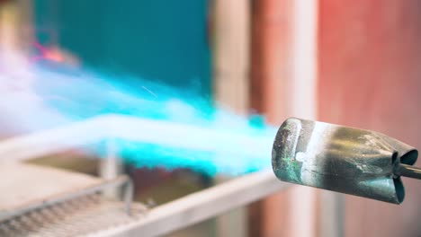 man lighting large blow torch with a lighter which produces a fireball