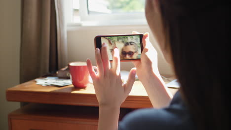 woman looking at her pictures on her phone