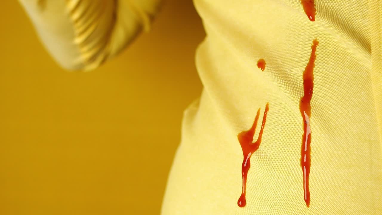 primer plano de una mancha de ketchup en una camisa amarilla