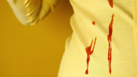 close-up of a ketchup stain on a yellow shirt