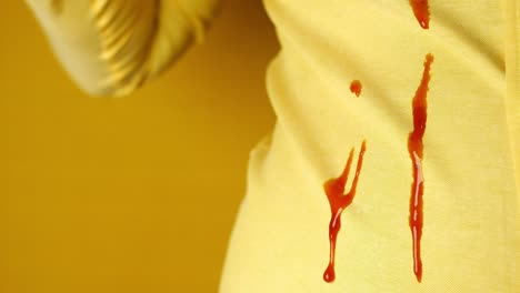 primer plano de una mancha de ketchup en una camisa amarilla