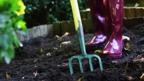 senior woman digging with garden fork