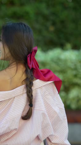 woman with a red bow in her braided hair