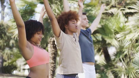 Multiethnic-sportspeople-doing-yoga-in-park