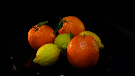 naranjas y limones sobre fondo negro, cítricos con vitaminas naturales
