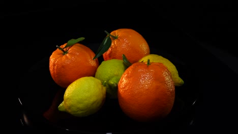 oranges and lemons on black background, citrus fruits with natural vitamins