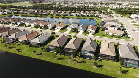 aerial of a sunny suburban neighborhood in tropical climate circling the lake